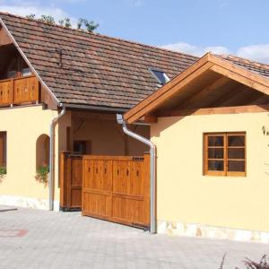uma casa com um portão de madeira e uma garagem em Villa Giulia Vendégház em Verpelét