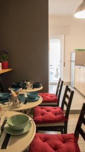 un comedor con una mesa con sillas acolchadas de color rojo en B&B Brothers Suite Vomero en Nápoles