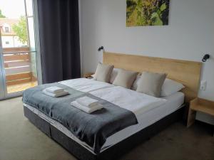ein Schlafzimmer mit einem großen Bett mit zwei Handtüchern darauf in der Unterkunft PROMENADE in Podersdorf am See