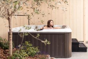 a woman is sitting in a bath tub at Hotel Berghang in Collepietra