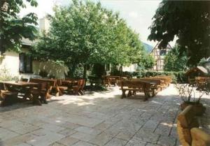 a group of wooden tables and benches in a courtyard at Hotel Alter Posthof in Spay