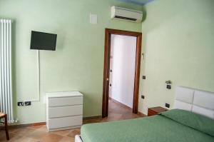 ein Schlafzimmer mit einem Bett, einem TV und einer Tür in der Unterkunft Appartamenti Medusa in Alba Adriatica