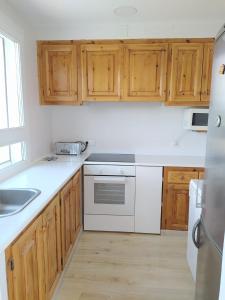 una cocina con electrodomésticos blancos y armarios de madera en Apartamento en casa de campo cerca de la playa, en Pals