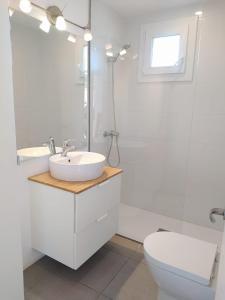 a white bathroom with a sink and a toilet at Apartamento en casa de campo cerca de la playa in Pals