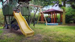 a playground with a yellow slide in a yard at Studio Ania in Stegna