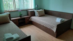 een kamer met 2 bedden en een raam bij Апартамент Миг in Haskovo