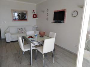 Una sala de estar con una mesa y sillas y un sofá. en Le Palais du Tropique appartement vue mer 5é étage avec ascenseur, en Juan-les-Pins