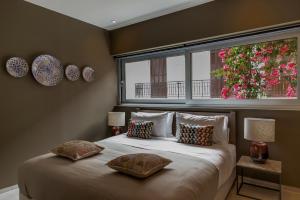 a bedroom with a bed with two pillows and a window at Azur by Stylish Stays in Athens