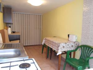 a kitchen with a table with green chairs and a sink at Casa Vlad in Constanţa