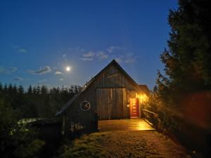 a barn with a red door at night at Rennsteigscheune in Steinbach am Wald