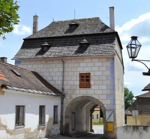 un grand bâtiment blanc avec une porte voûtée dans l'établissement Apartmán Horní Brána, à Telč