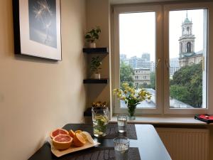 uma mesa com um prato de laranjas e uma janela em Good Time Apartments Warsaw - Świętokrzyska em Varsóvia