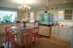 a kitchen with a center island with red bar stools at The Old Deer House in Bodmin