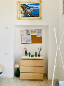 un comò in una stanza con un dipinto sul muro di Lucy's house - comfortable apartment in Amalfi ad Amalfi