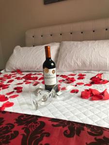 a bottle of wine sitting on top of a bed at Vila Noel Premium in Penedo