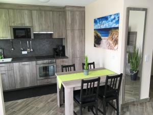eine Küche und ein Esszimmer mit Tisch und Stühlen in der Unterkunft SONNENSEITE 2 in Laboe