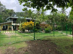 una valla verde frente a una casa en Casa Amarilla, en Esterillos