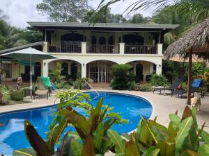 una casa con piscina frente a ella en Casa Amarilla, en Esterillos