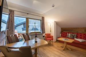 sala de estar con mesa y sofá en Ferienhotel Sonnenheim, en Oberstdorf