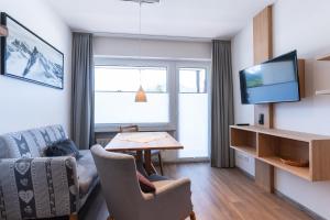 een woonkamer met een bank, een tafel en een tv bij Ferienwohnung I. Benne in Oberstdorf