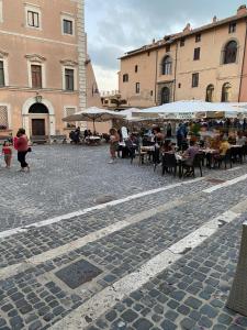 un gruppo di persone sedute ai tavoli in una strada di Fra Em Doria "Giubileo 2025" a Nettuno Altre 17 foto
