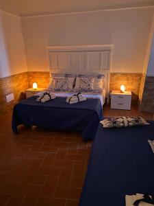 een hotelkamer met 2 bedden en 2 lampen bij FRA EM DORIA in Nettuno