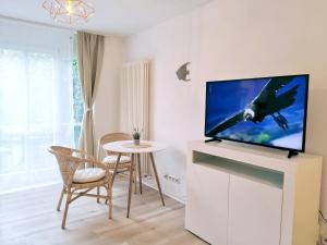 a living room with a tv and a table with chairs at Lillys Apartment Kempten in Kempten