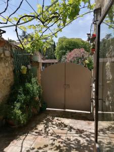 a gate to a house with plants and flowers at Maison de charme pittoresque Villeneuve lez Avignon in Villeneuve-lès-Avignon