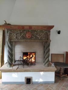 a brick fireplace with a fire in it at Marrucheto in Giuncarico