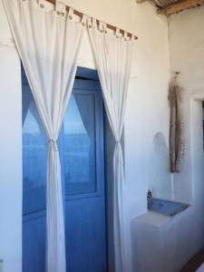 a blue door with a curtain and a window at Casa Gianni Alicudi in Alicudi