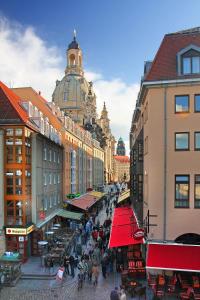 a group of people walking down a street with buildings at Aparthotels Münzgasse An der Frauenkirche in Dresden