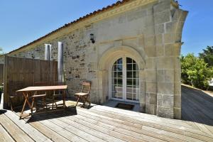 una terrazza in legno con tavolo e sedia su un edificio di Domaine du Galon d'Or ad Arvert