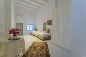 Habitación blanca grande con cama y mesa en Vita Real Estate en Hydra