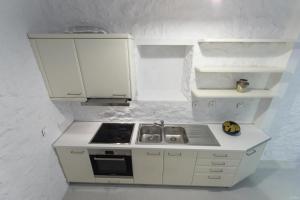 una pequeña cocina blanca con fogones en Vita Real Estate, en Hydra