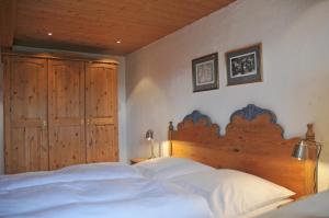 een slaapkamer met een groot bed met een houten hoofdeinde bij Das Kätnerhaus Nordsee in Langenhorn