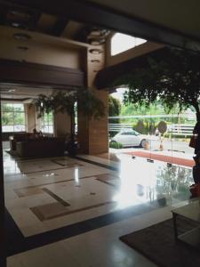 vistas a un vestíbulo con un árbol en el suelo en DE GREEN INN Kebon Jeruk en Yakarta