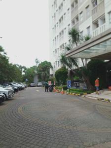 eine Kopfsteinpflasterstraße in einer Stadt mit geparkten Autos in der Unterkunft DE GREEN INN Kebon Jeruk in Jakarta