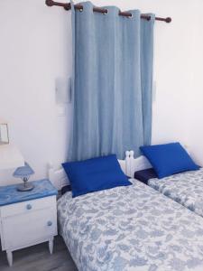a bedroom with two beds and a blue curtain at Yacht Front Studio - No 5 in Ios Chora