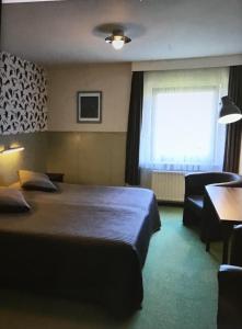 a hotel room with two beds and a television at Hotel Heynen in Valkenburg