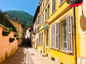 an alley in an old town with yellow buildings at appartement Breil sur Roya centre in Breil-sur-Roya