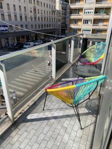 una sedia e un ombrellone seduti su un balcone di Hotel Stradivari a Milano