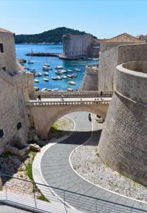 a bridge over a river with boats in the water at Apartman Roseta in Dubrovnik