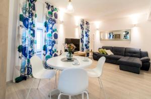 Apartman Roseta في دوبروفنيك: غرفة معيشة مع طاولة وكراسي بيضاء