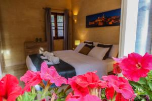 a bedroom with a bed with pink flowers in the foreground at Ta' Matmura Farmhouse in Għarb