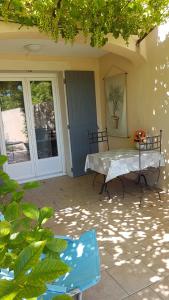 un patio con mesa y sillas frente a una casa en fleur de garance, en Le Thor