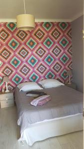 a bedroom with a large bed with a colorful wall at fleur de garance in Le Thor +48 photos