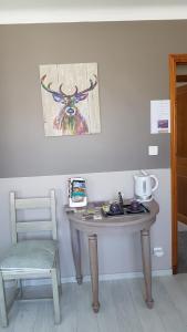 a table in a room with a chair and a painting at fleur de garance in Le Thor