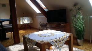 uma sala de estar com uma mesa e uma televisão em Ferienwohnung-Panoramablick em Gemünden an der Wohra