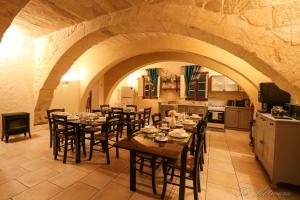 comedor con mesas y sillas y cocina en Ta' Matmura Farmhouse, en Għarb