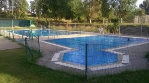 a large swimming pool with a fence around it at Casa Rural 1904 in Tubilla del Lago